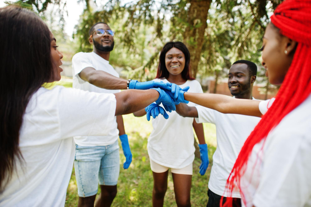 group-happy-african-volunteers-put-hands-hands-park-africa-volunteering-charity-people-ecology-concept